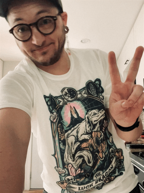 Tonee wearing a 'luck dragon' tee, flashing peace sign, with 'dramatic' filter applied